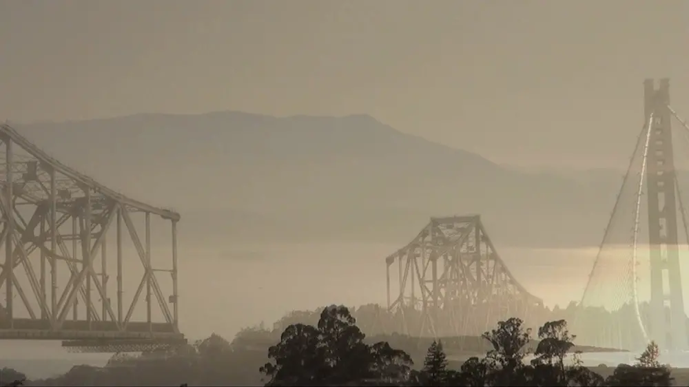 photo montage of the old and new San Francisco Bay Bridge with silhouetted trees along the lower edge 