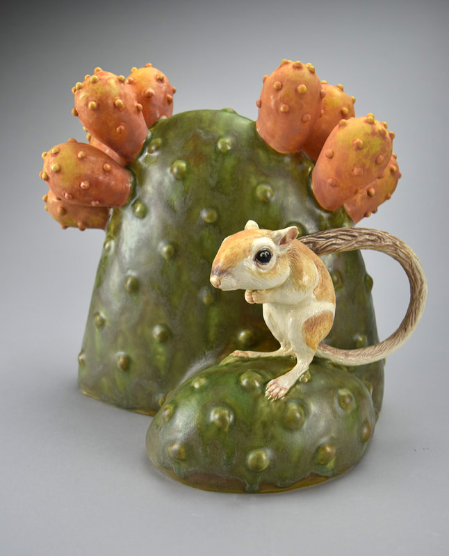 Ceramic sculpture of a Kangaroo rat and cactus.