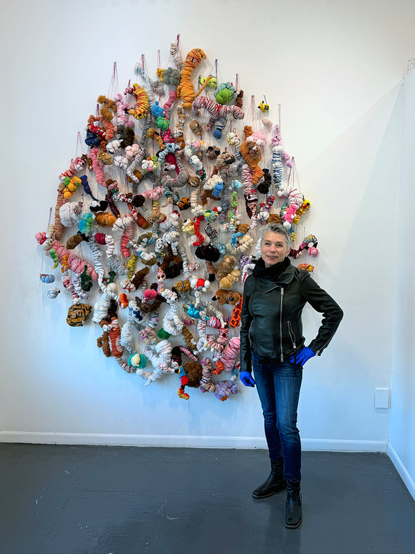 artist Jann Nunn with artwork made of multiple stuffed animals tied with string