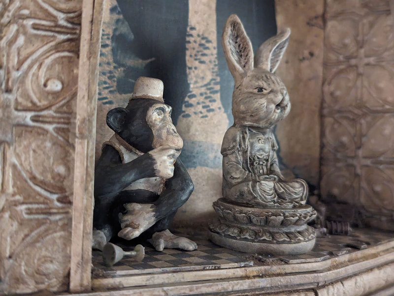 A detail of a sculpture showing  a chimp and a bunny