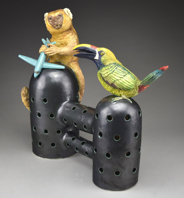 Sculpture of a King golden lemur with airplane and Emerald toucanet.