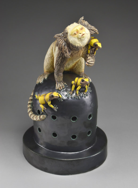 Ceramic sculpture of a marmoset with poison
dart frogs.