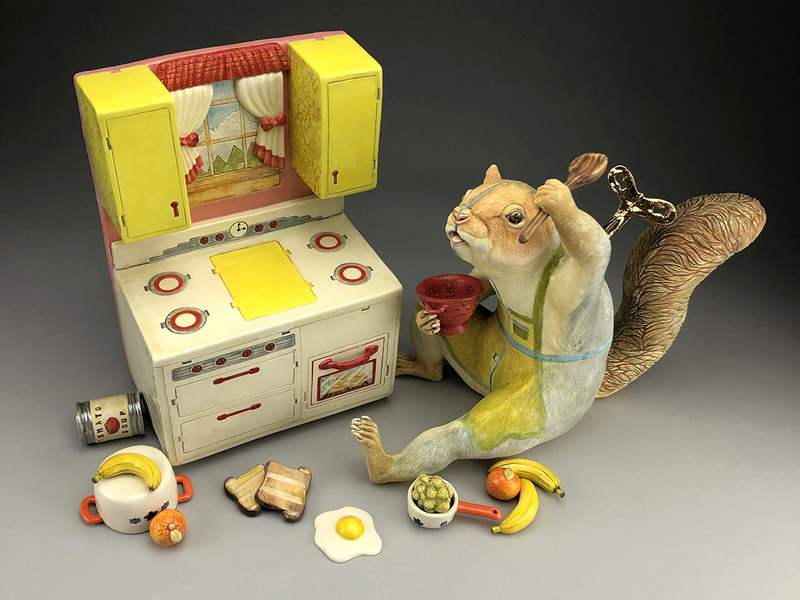 Ceramic sculpture of a squirrel with toy stove and food items.