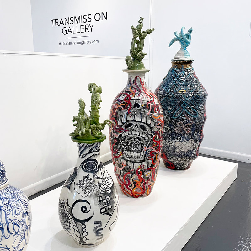 large wildly colored and patterned vases with lids that have complex curved shapes, one looks like a dragon