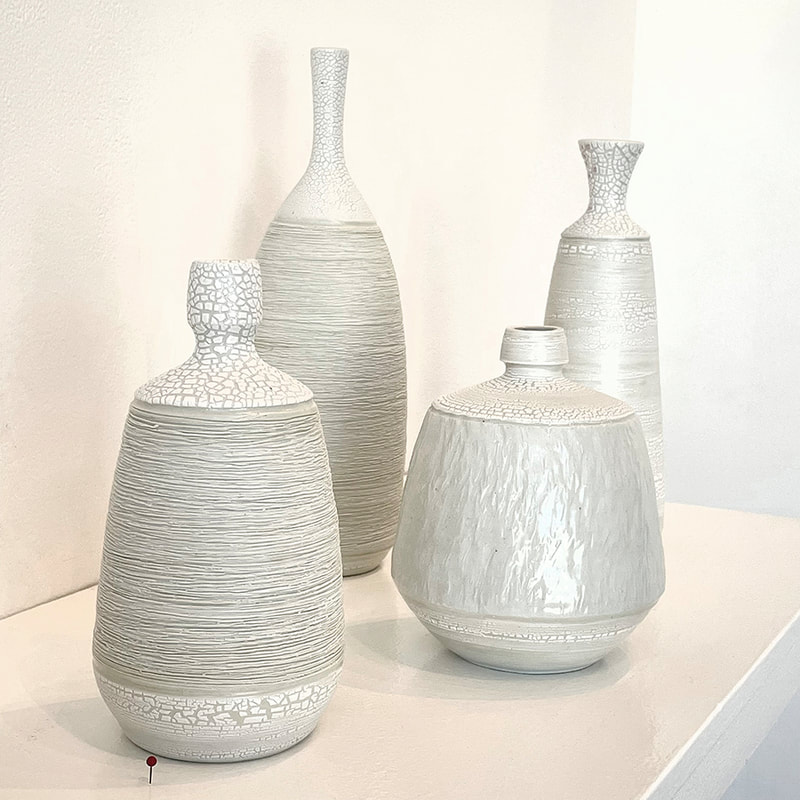 Four textured white bottles
