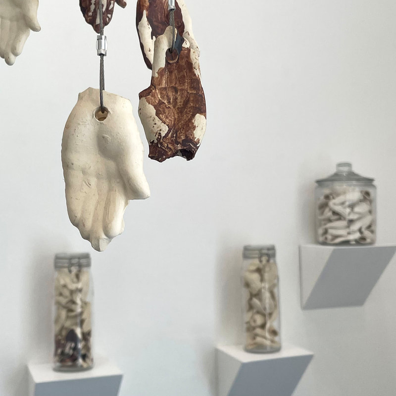 Art installation of many suspended ceramic hands 