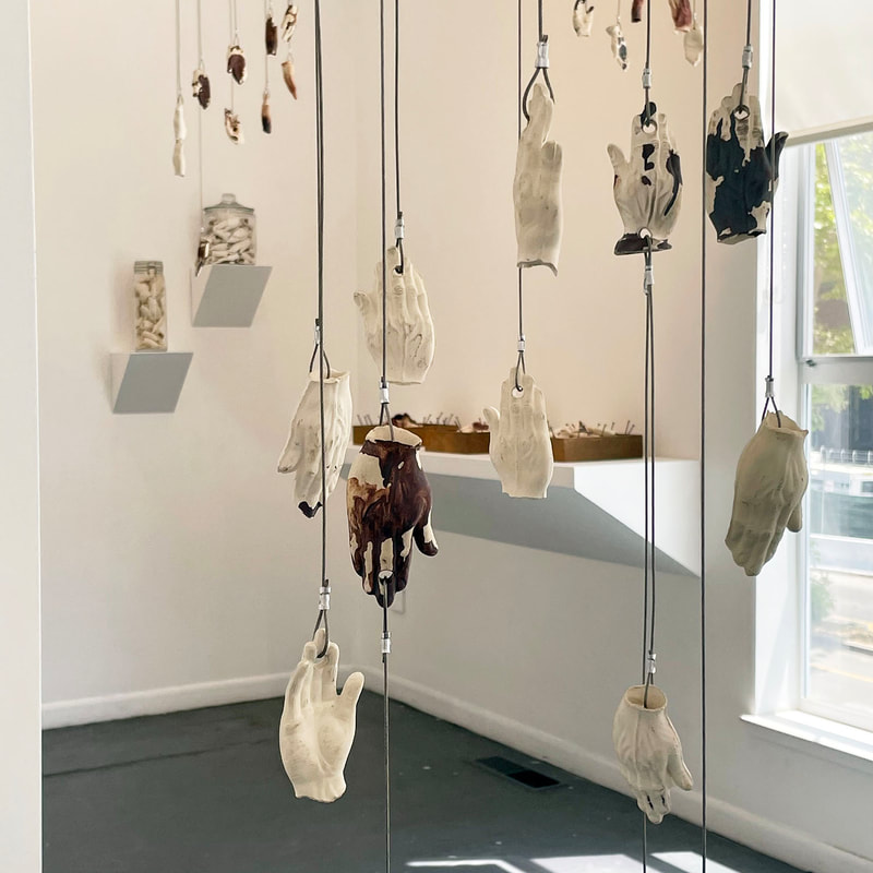 Art installation of many suspended ceramic hands 