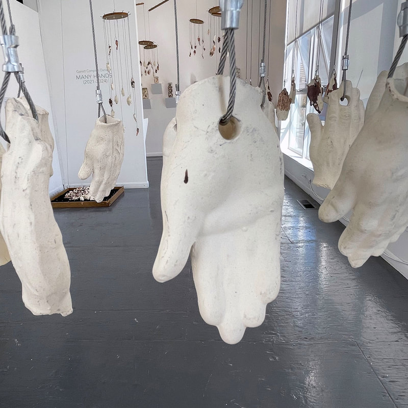 Art installation of many suspended ceramic hands 