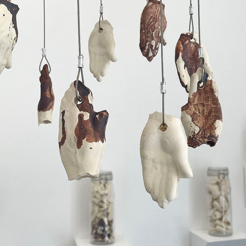 Art installation of many suspended ceramic hands 