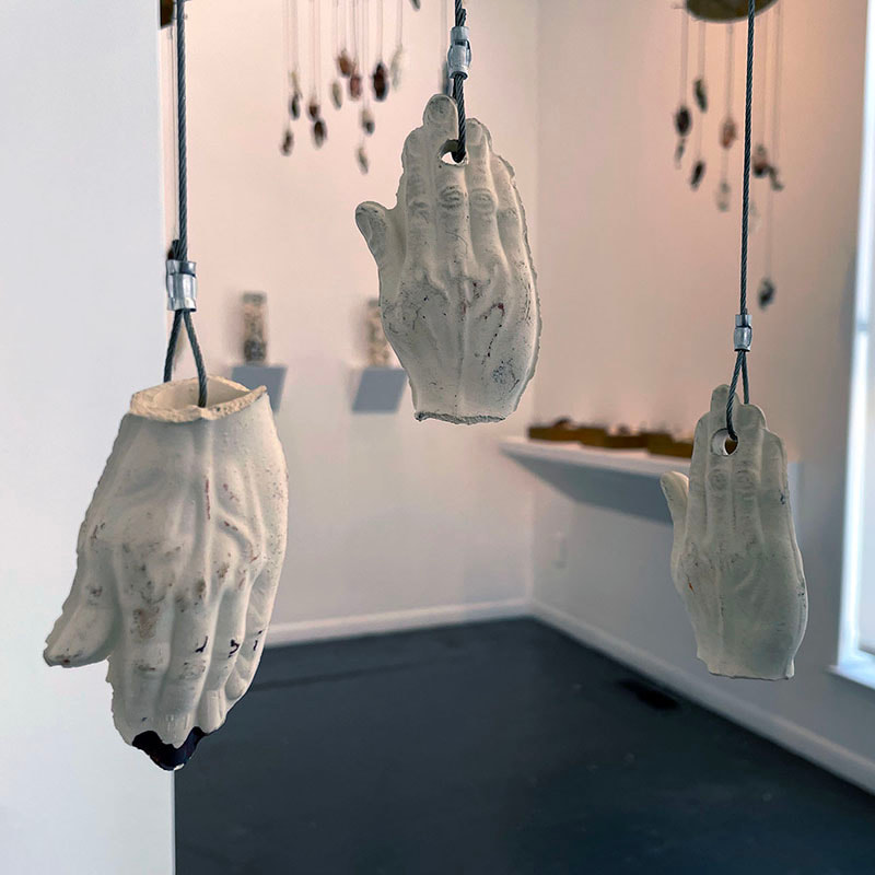 Art installation of many suspended ceramic hands 