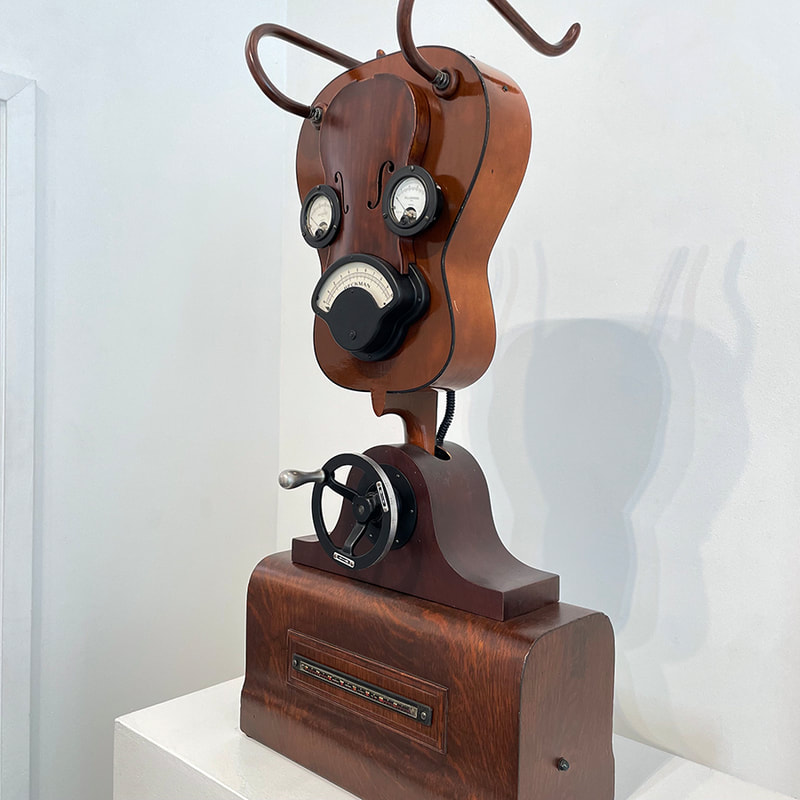 Sculptural face made with guitar, hand crank and dials