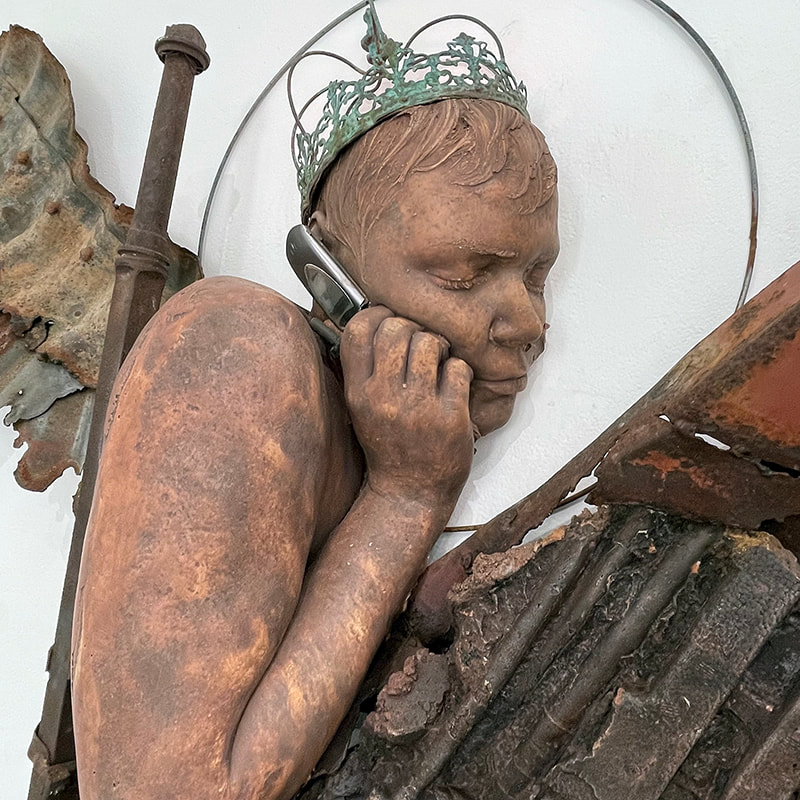 detail of a sculpture made of many objects, a person holding a flip phone, wearing a crown