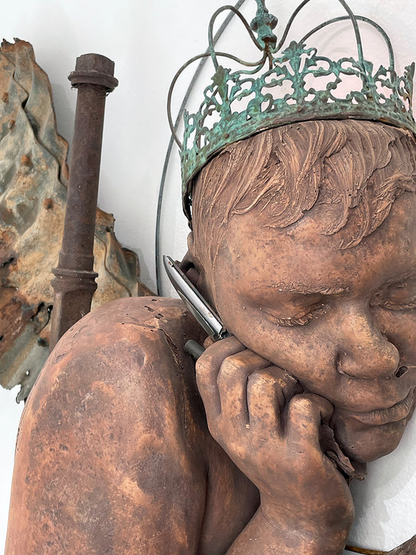 detail of a sculpture made of many objects, a person holding a flip phone, wearing a crown