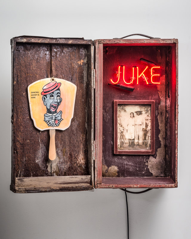 Heirloom handled box with a minstrel fan, portrait of a couple and the word "juke" in neon