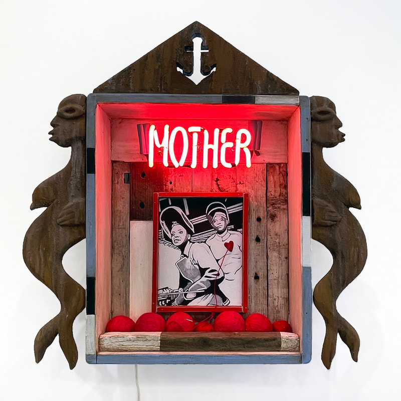 artwork with two wood carvings of mermaids attached to a rough hewn house shape with the word "Mother" in red neon inside the house shape and above an ink drawing of two women laborers stitched with red thread and with balls of red thread in front of the drawing 