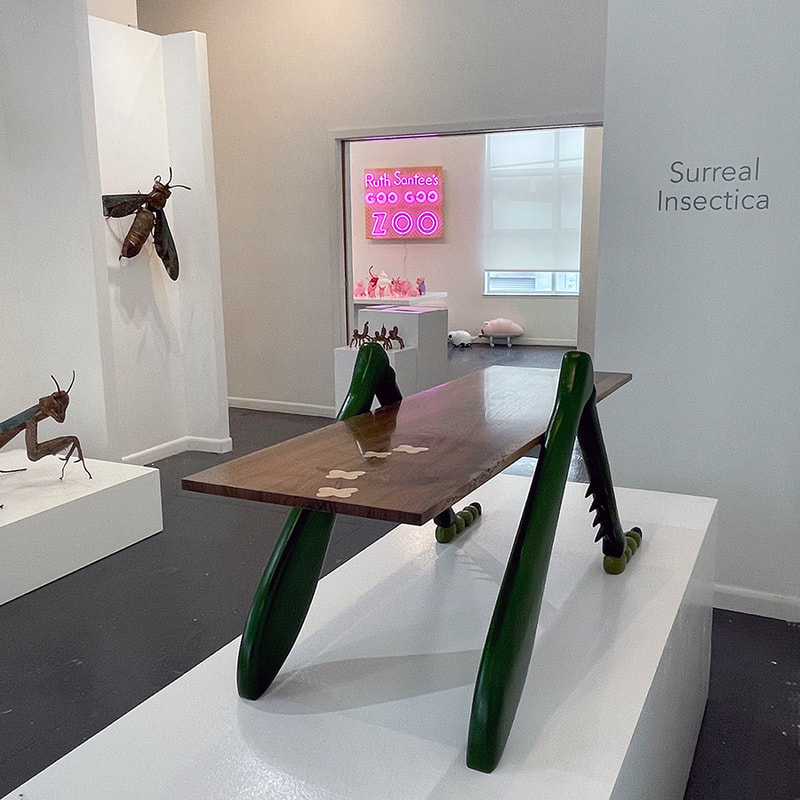 Art gallery with insect themed art including a table with grasshopper legs