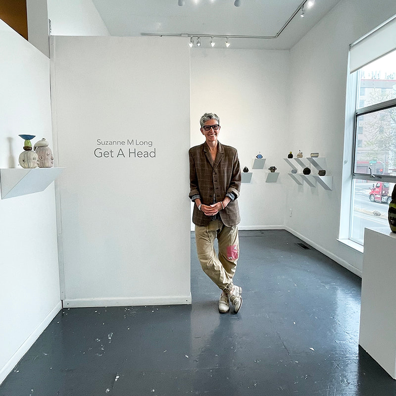 Artist Suzanne Long with ceramic head sculptures
