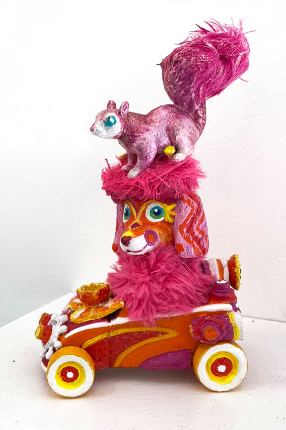 silly dog in a tiny car with squirrel on its head