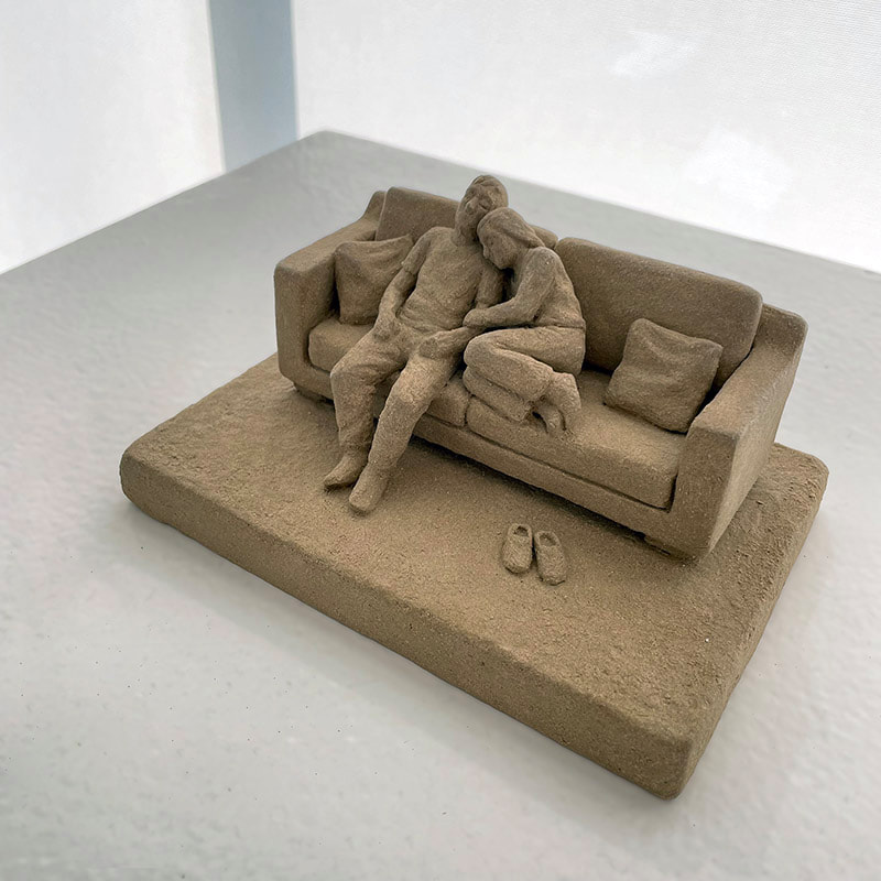 Ceramic art a couple sitting close together on a couch